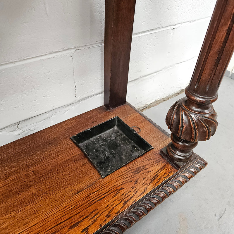 Stunning English Oak gothic style hallstand with one drawer, mirror and 6 hooks and two compartments for umbrellas. It is beautifully decorated and carved. It is in good original detailed condition. 