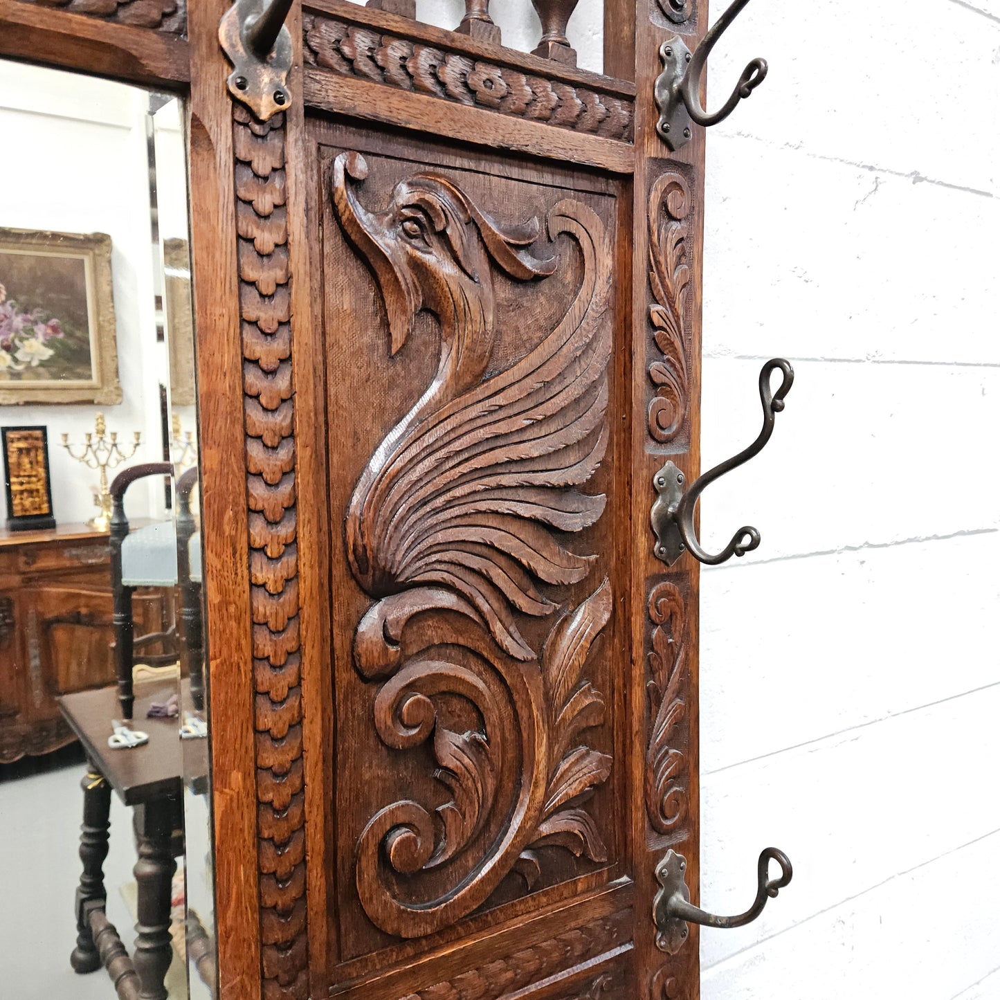 Stunning English Oak gothic style hallstand with one drawer, mirror and 6 hooks and two compartments for umbrellas. It is beautifully decorated and carved. It is in good original detailed condition. 