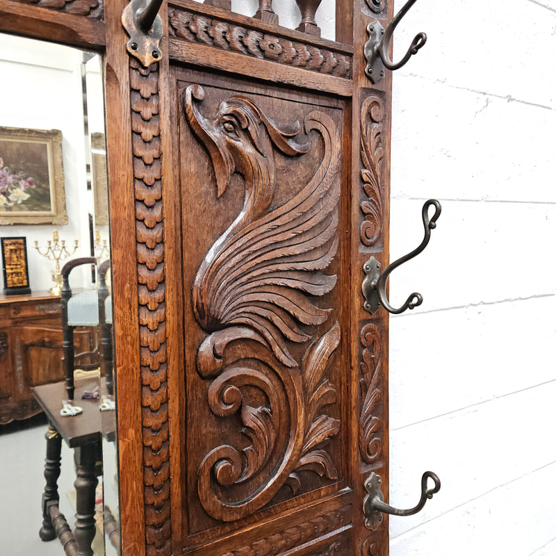 Stunning English Oak gothic style hallstand with one drawer, mirror and 6 hooks and two compartments for umbrellas. It is beautifully decorated and carved. It is in good original detailed condition. 