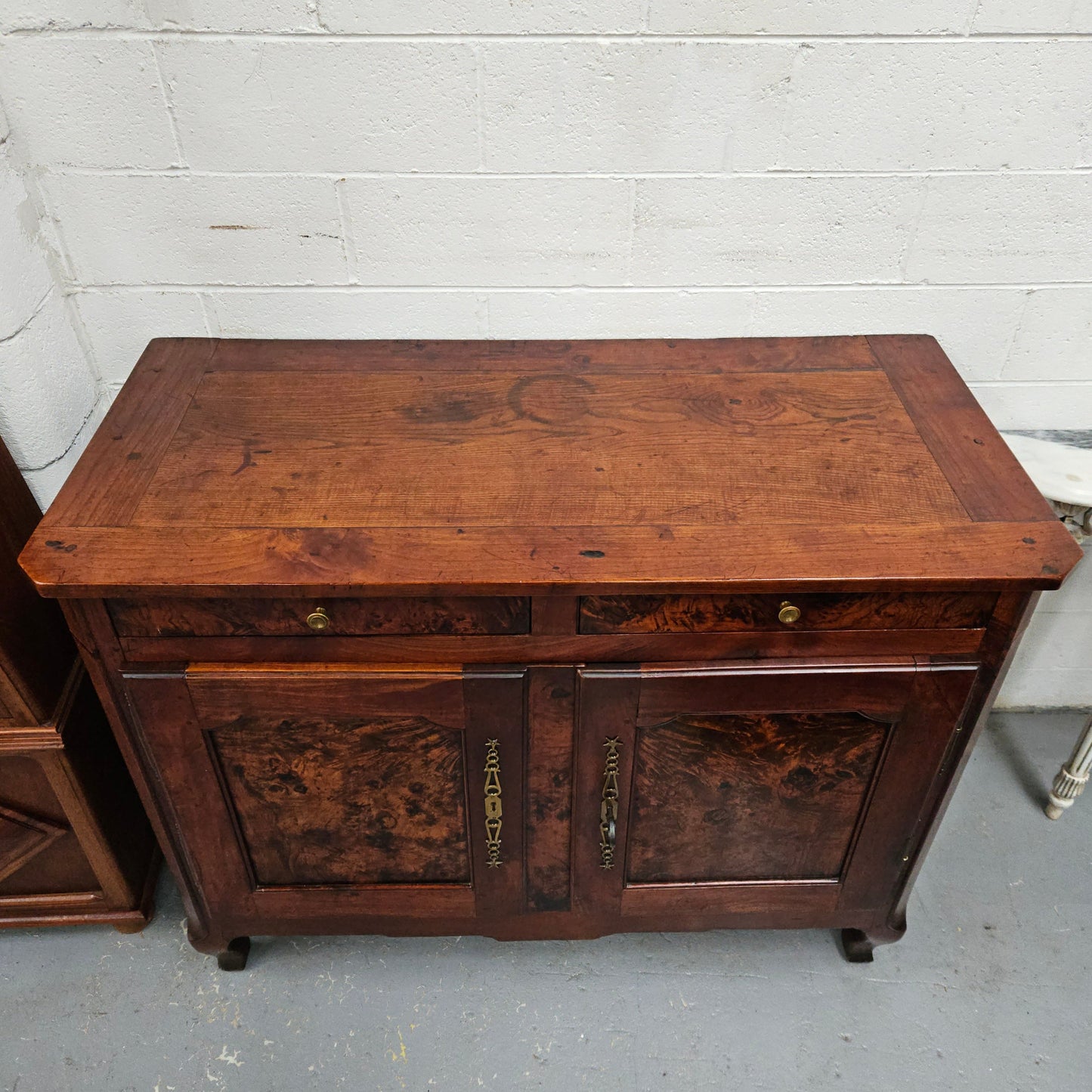 Stunning early 19th Century Elm buffet featuring two highly figured elm doors and drawers, it provides ample storage and is in good original condition.