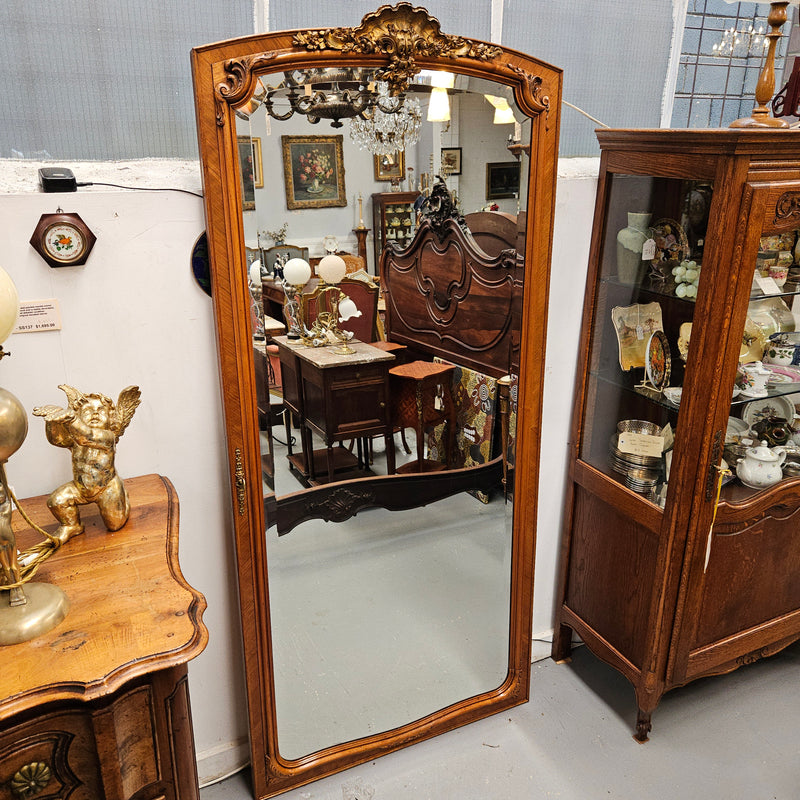 A fabulous tall Louis XV style Walnut floor/mantle mirror featuring decorative bronze gilt ormolu mounts. It still contains its beautiful original bevelled edged mirror. It has been sourced from France and is in good original detailed condition.