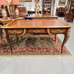 An exceptional French 19th Century Louis XV style "Bureau Plat" tooled leather top desk. Made from kingwood and rosewood, It has superb gilt cast ormolu mounts all the way around which means it can be used floating in the center of a room. In very good restored condition.