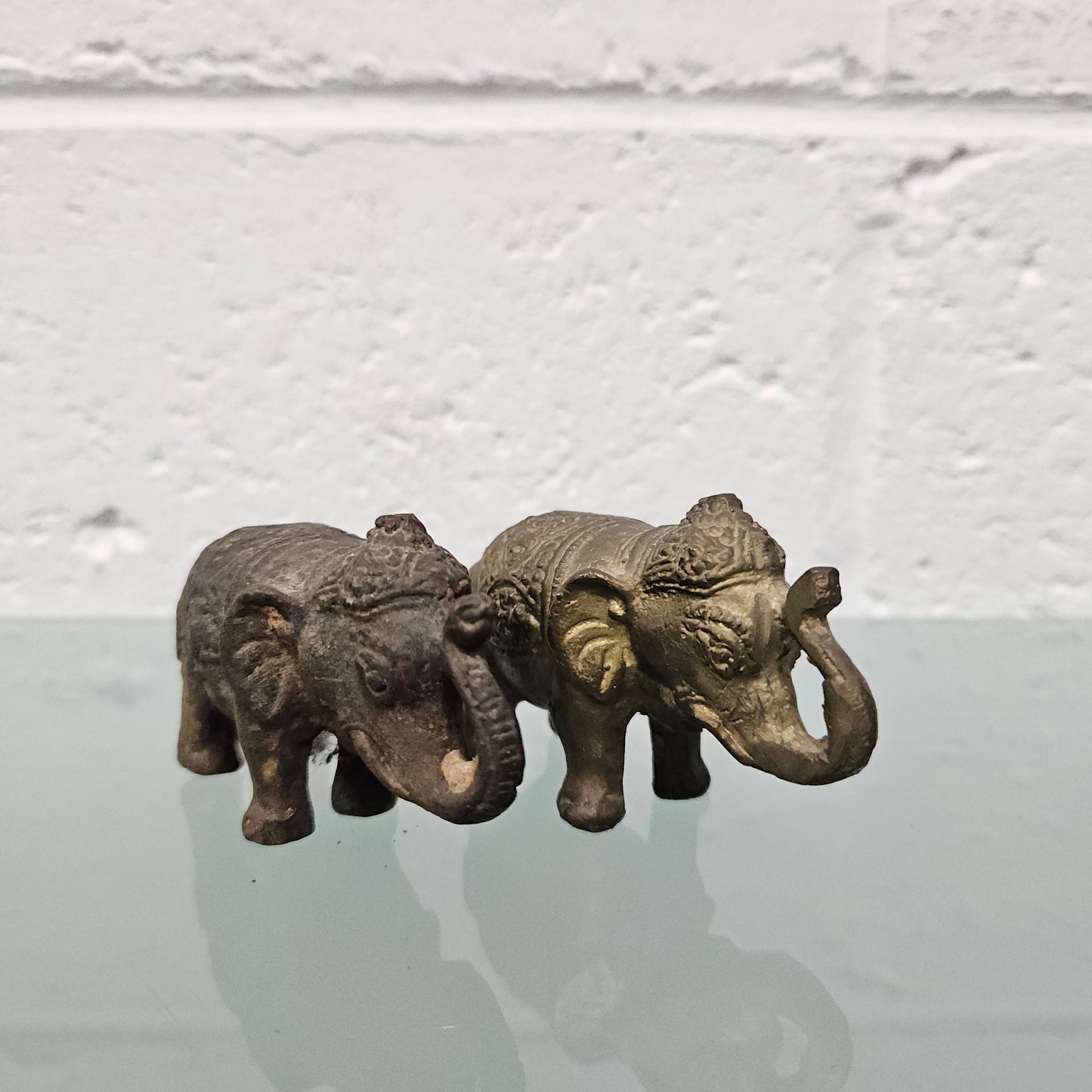 Pair of vintage aged brass elephants with raised trunks, in good original condition.