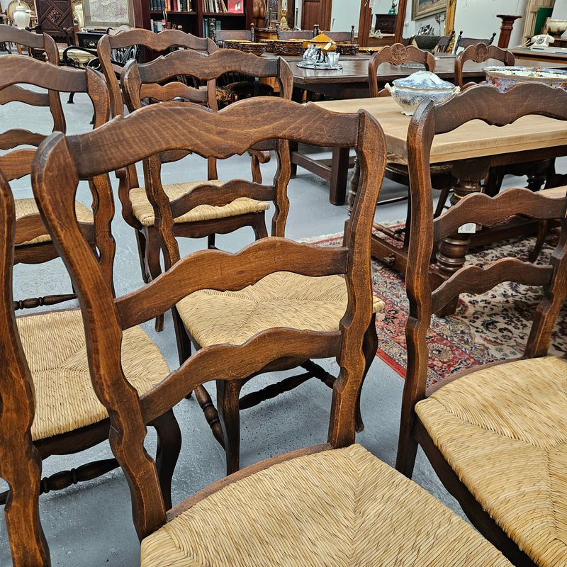 Set of ten French oak rush seats with eight dining chairs and two carvers. They have a comfortable wide rush seat and are in good original condition.