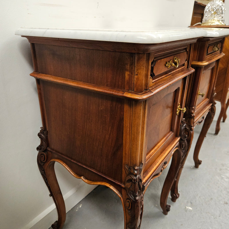 Pair of French Walnut Louis XV Style white marble top bedside cabinets. Featuring beautiful parquetry work and decorative carvings throughout. Sourced directly from France and in good original detailed condition.