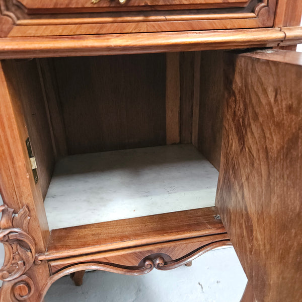 Pair of French Walnut Louis XV Style white marble top bedside cabinets. Featuring beautiful parquetry work and decorative carvings throughout. Sourced directly from France and in good original detailed condition.