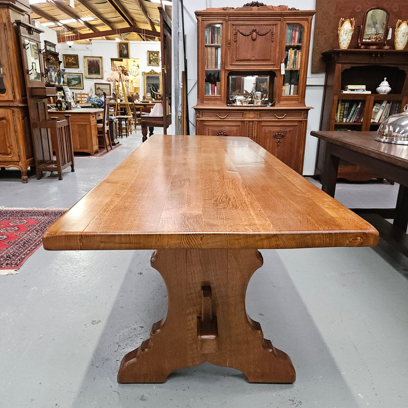 Stunning French oak monastery dining table. The top is supported on a large trestle base, and united with a single stretcher secured at each end with oak pegs. Sourced directly from France and is in good restored condition. It can seat 6-8 people comfortably.