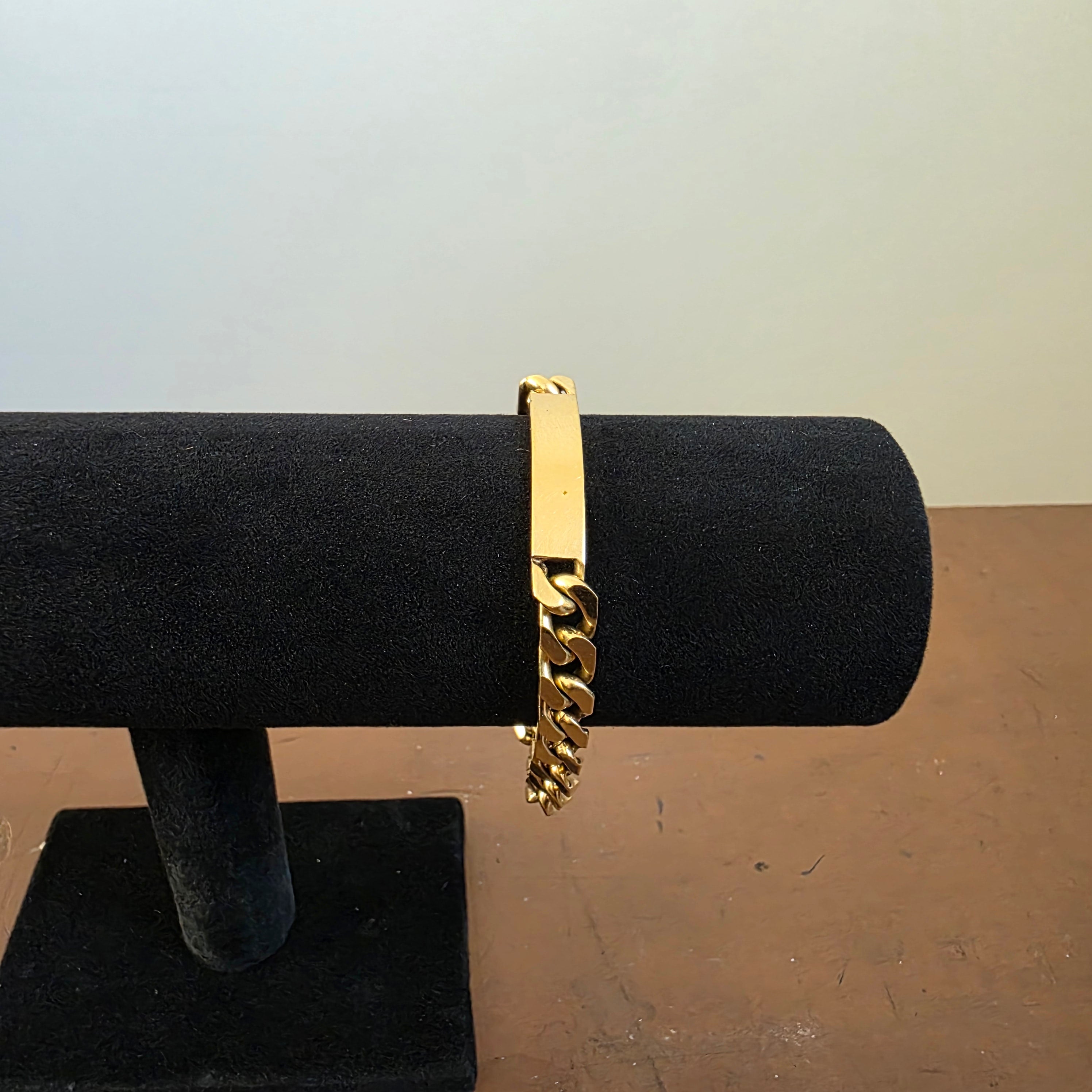 Vintage Americ identity bracelet displayed around a black jewellery stand