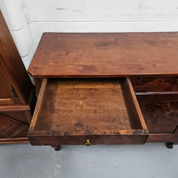 Stunning early 19th Century Elm buffet featuring two highly figured elm doors and drawers, it provides ample storage and is in good original condition.