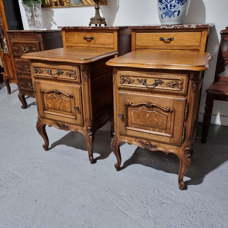 A Rare pair of Antique French Oak Louis XV style wooden top bedside cabinets. Featuring decorative carvings and classical Louis XV cabriole legs. These have been sourced directly from France and are in good original detailed condition.