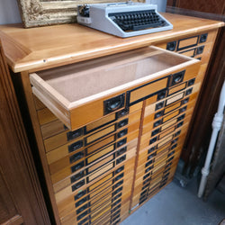 Open removable glass-topped drawer in a vintage specimen collector’s cabinet