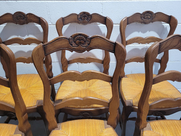 A set of 6 French Louis XV style oak dining chairs with rush seats in good original condition. All chairs have been detailed and re-glued where needed.