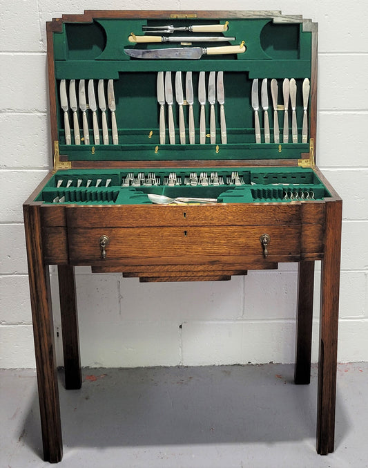 English Oak beautifully fitted cutlery table with a lift up top and drawer. Contains extensive silver plate part cutlery service by Elkington. In good original condition.