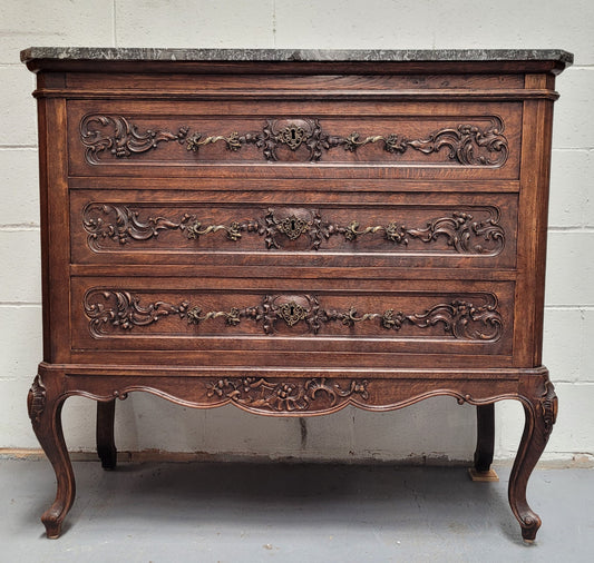 French Oak Louis XV style marble top chest of three drawers. It has beautiful carvings on the drawers with lovely decorative handles all toped with a stunning black and white marble top. In good original detailed condition.