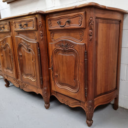 A Beautifully carved French Walnut Louis XV style four door sideboard. Plenty of storage space with four doors as well as four drawers. It is in good original detailed condition.