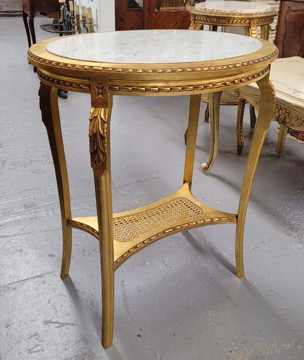 Impressive French oval Louis XVI style gilt and white marble topped two tier lamp/side table. It has been sourced from France and is in good original detailed condition.