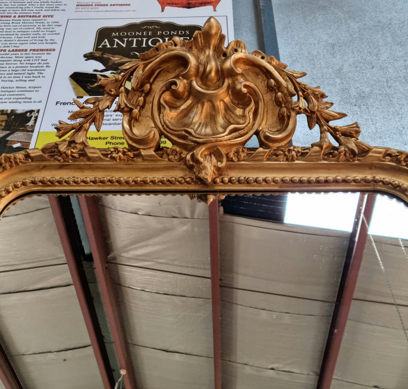 Grand French 19th Century Napoleon III style gilt mantle mirror. Frame has detailed acanthus leaf carving patterns and a beautiful ornate crest on top. In good original condition.
