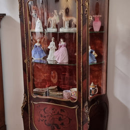 French Louis XV style marquetry inlaid vitrine with ormolu mounts and curved glass. The inside in lined with a red velvet upholstery and has two glass shelves. It has been sourced from France and is in good original detailed condition.