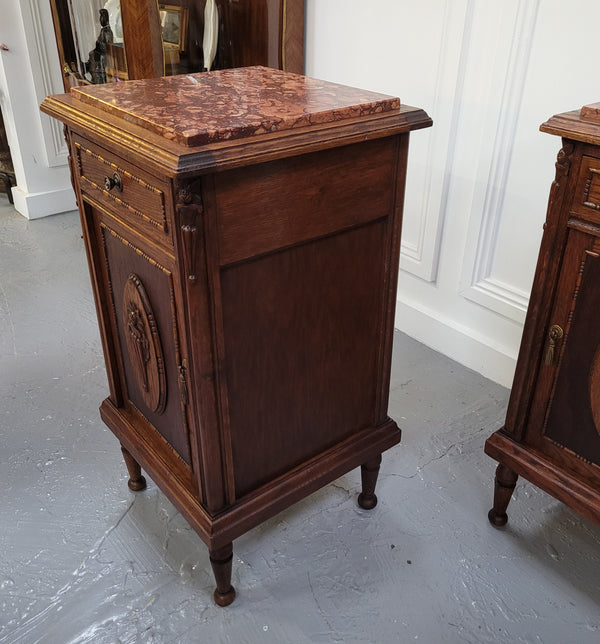 Pair of French Art Deco Oak and rouge inset marble top bedside cabinets. They have one drawer and one cupboard with elegant carving on the door. They have been sourced from France and are in good original detailed condition.