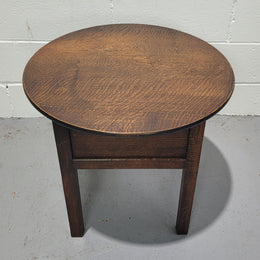 Fabulous round oak side table which also has a hidden sewing box underneath with lovely original blue satin lining and Includes pictured sewing items. It is in good original condition.