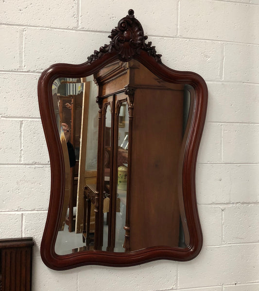 Lovely French mahogany wall mirror with carved detail, beveled glass and in good condition.