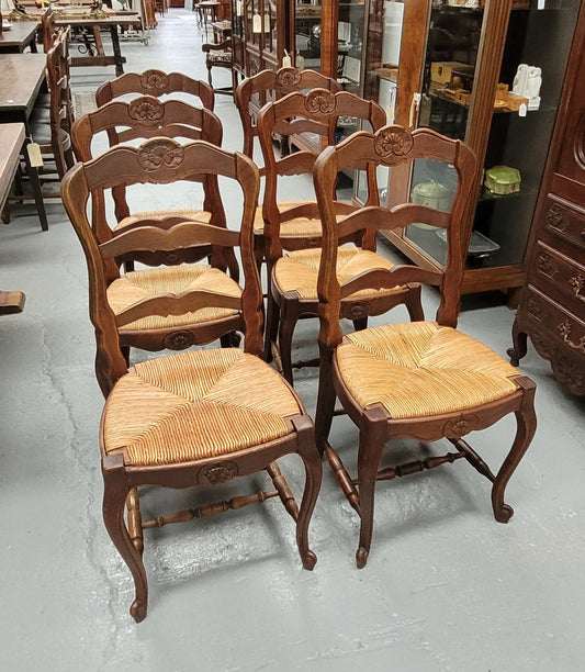 Set of six Louis XV style French Oak rush seat dining chairs. These chairs are very sturdy and have been professionally re-glued to ensure long lasting strength and sturdiness. They are in very good original detailed condition.