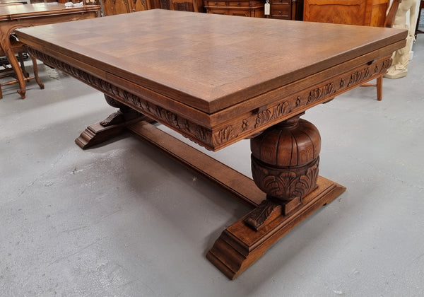 French Oak Renaissance style extension table with a stretcher base and heavily carved bulbous. When the table fully extends it measures 300 cm and can be used with both sides out or with only the one leaf out either side. It is in good original detailed condition.