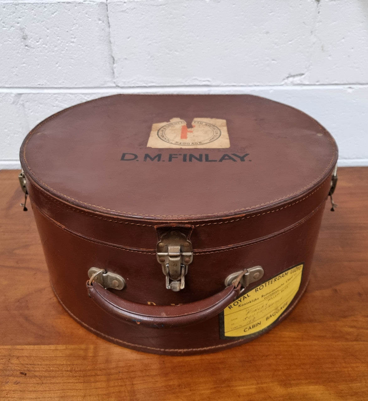 Charming solid leather hatbox with patterned fabric interior and two interior pockets. Interior stamp is for The Mutual Store Melbourne. Bears paper stamps for P&O Cruise Passenger” & “Peninsular  the top and D.M.F. in gold near the handle. Circa: Early 1900’s. 43 cm across and H:21 cm the lid.
