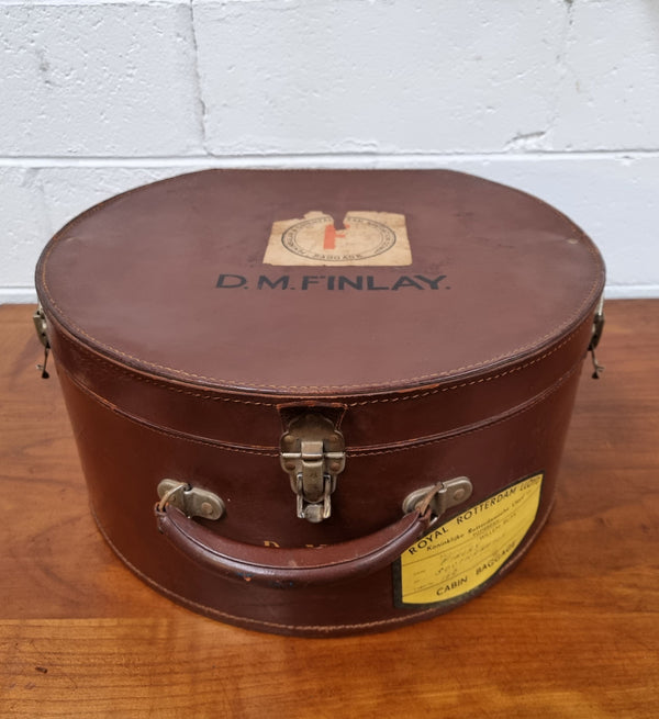 Charming solid leather hatbox with patterned fabric interior and two interior pockets. Interior stamp is for The Mutual Store Melbourne. Bears paper stamps for P&O Cruise Passenger” & “Peninsular  the top and D.M.F. in gold near the handle. Circa: Early 1900’s. 43 cm across and H:21 cm the lid.