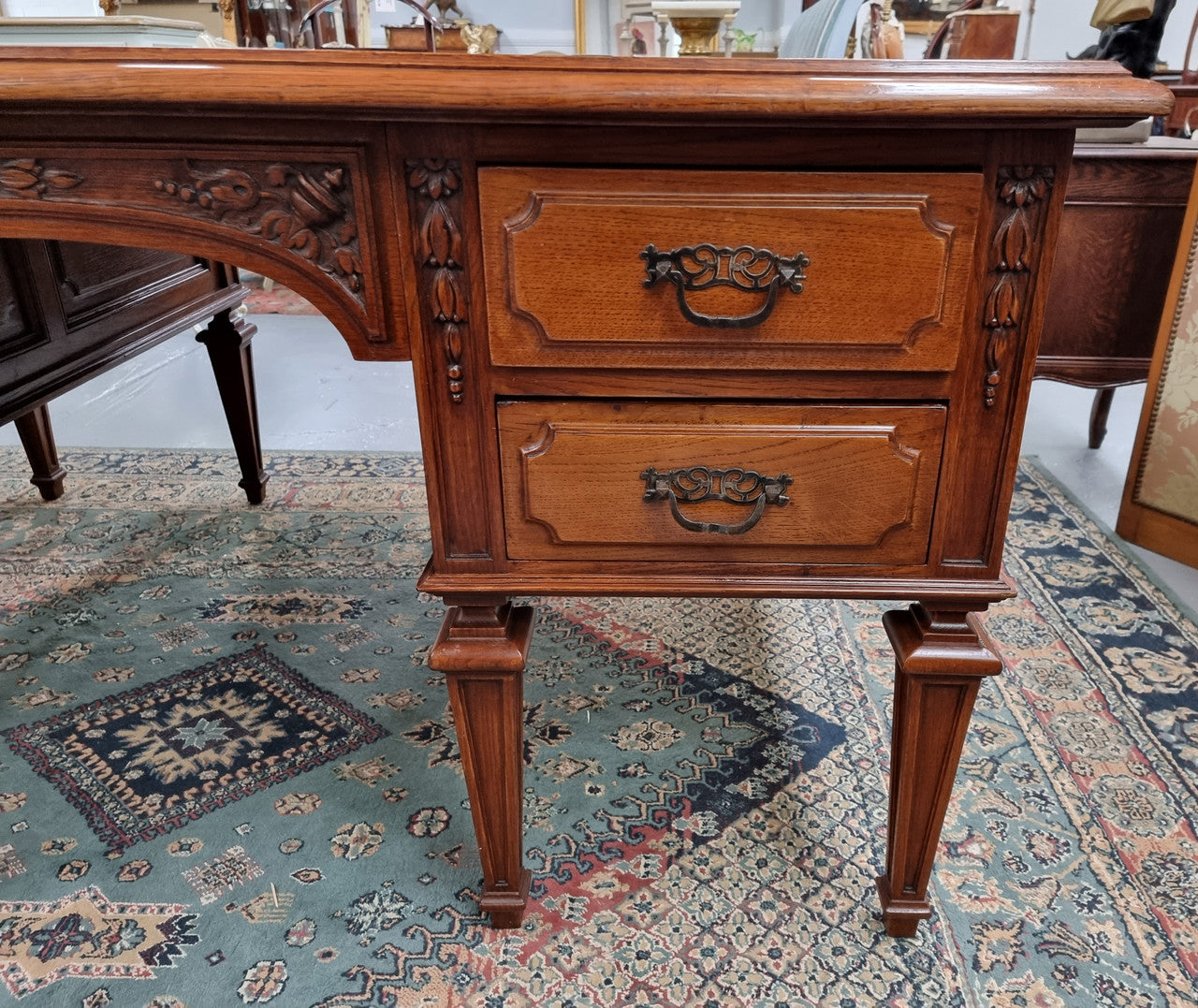 Substantial French Louis XVI style Oak partners desk. It has a beautiful leather top, two drawers on either side and decorative carvings throughout. Sourced from France and in good original detailed condition.