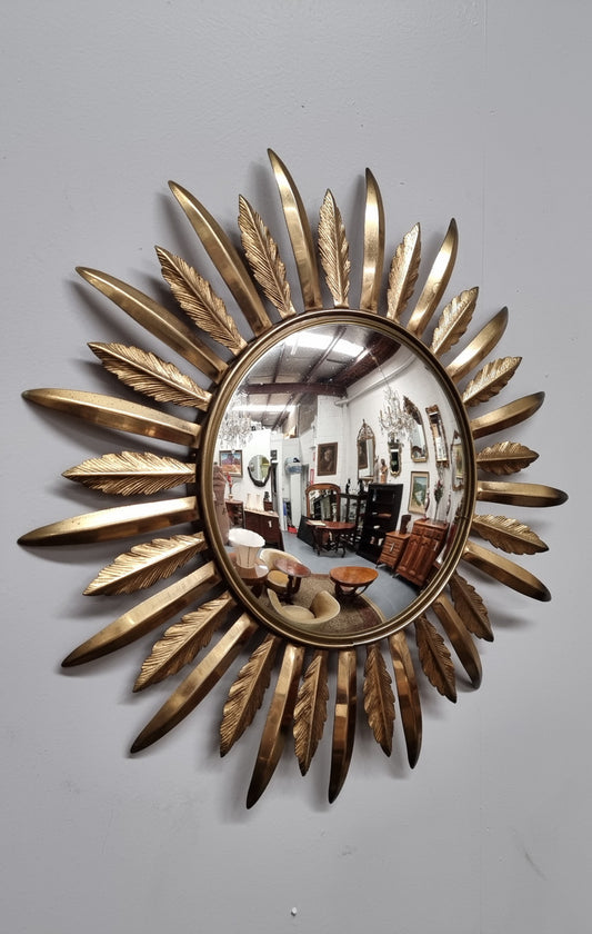 Decorative Vintage Starburst Convex mirror with feather shaped gilt metal . It has been sourced from France and in good original detailed condition.