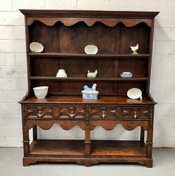 Fabulous Antique Tudor style Oak kitchen dresser with two drawers and two shelves. It is in good original detailed condition.