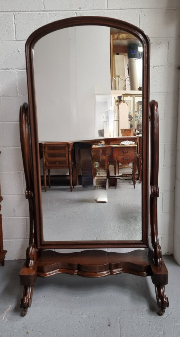 Antique Victorian 19th Century full length Mahogany cheval mirror. Mirror supported on two elegant scrolled upright support and stands on moulded base with four scrolled feet and castors.