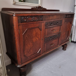 Art Deco Tudor style Oak sideboard with decorative carved detail. Plenty of storage space with two cupboards and four drawers. It has been sourced locally and is in good original detailed condition.