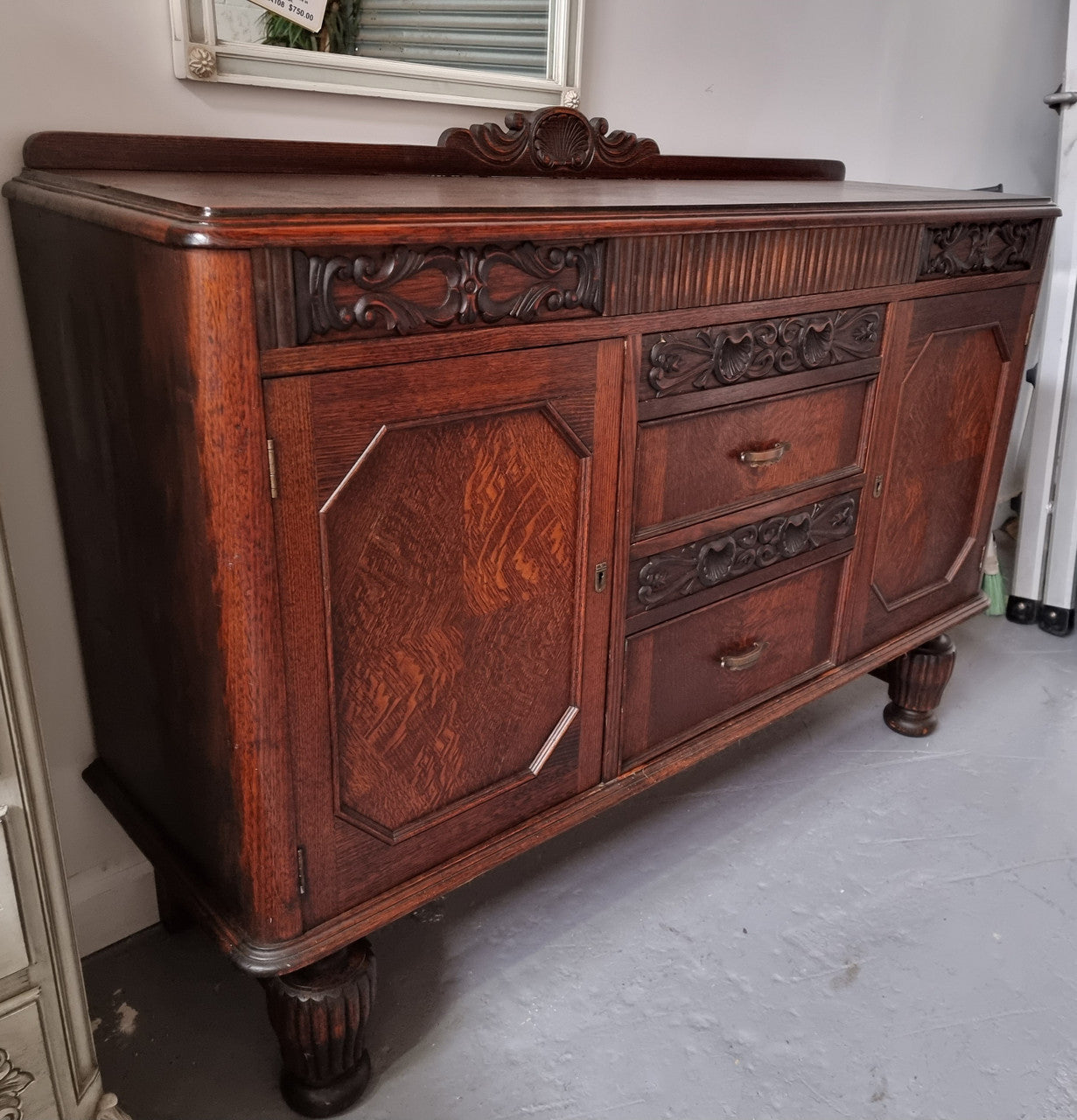 Art Deco Tudor style Oak sideboard with decorative carved detail. Plenty of storage space with two cupboards and four drawers. It has been sourced locally and is in good original detailed condition.