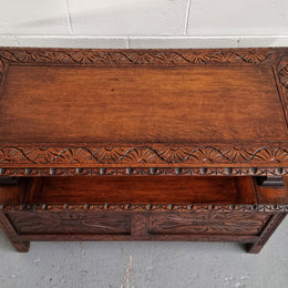 Unusual English Oak Monks Bench.  The tabletop is set onto a lift top chest in such a way that when the table is not in use, the top pivots to a vertical position and becomes the back of a Settle. Carved Lion table rests and carving to front.  In good, detailed condition.