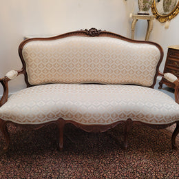 A late 19th Century French Walnut Louis XV style settee with a serpentine front. This settee upholstery is like new and is in very good condition.