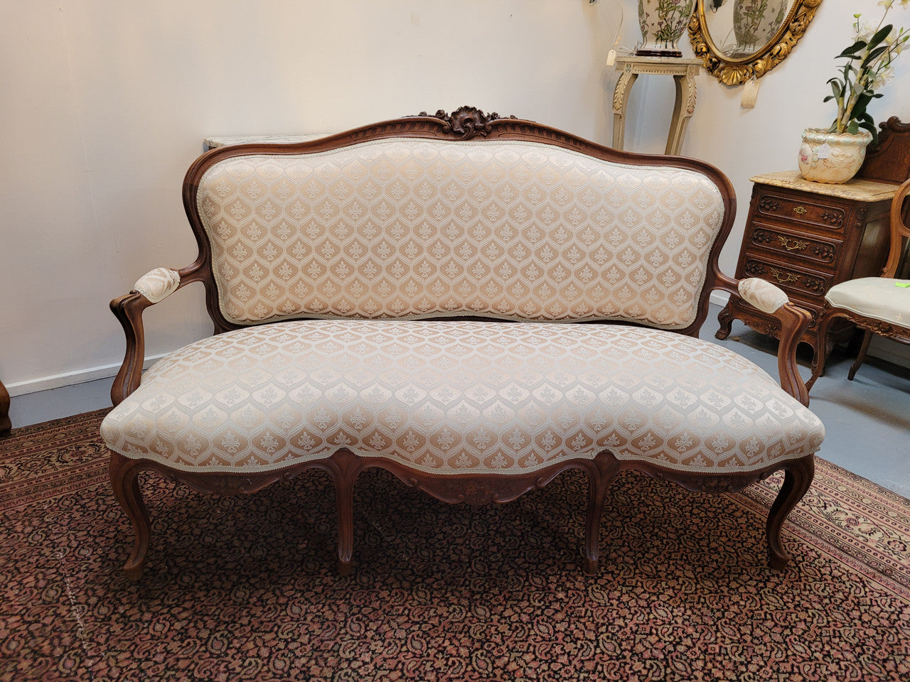 A late 19th Century French Walnut Louis XV style settee with a serpentine front. This settee upholstery is like new and is in very good condition.