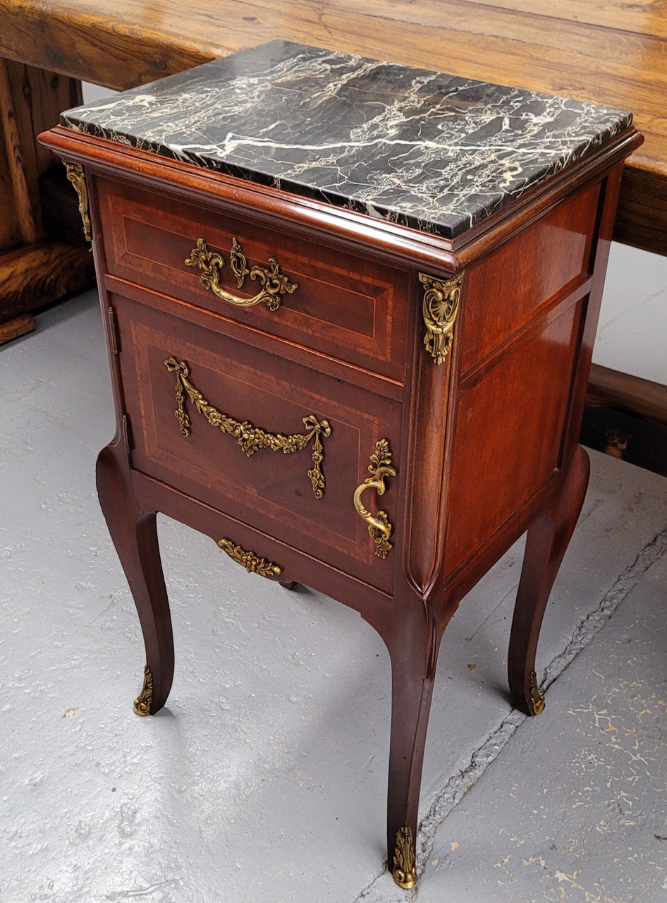 Appealing Louis XV style high quality bedside cabinets with black Portoro marble top and bronze mounts. They have been sourced from France and are in good original condition.