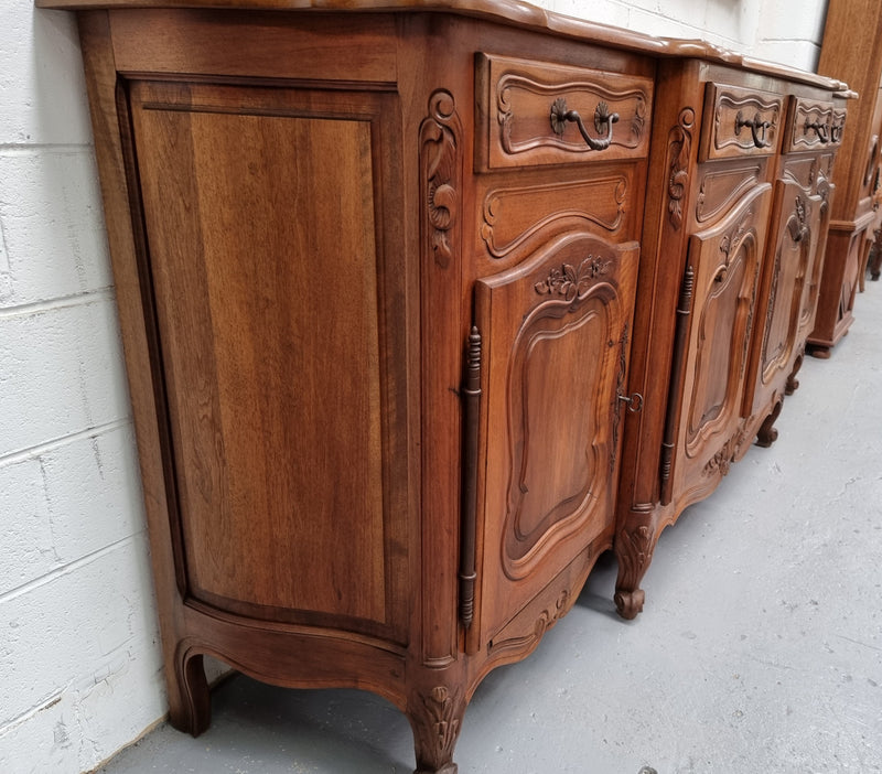 A Beautifully carved French Walnut Louis XV style four door sideboard. Plenty of storage space with four doors as well as four drawers. It is in good original detailed condition.