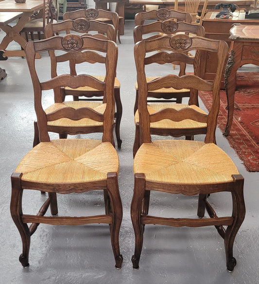 Set of six Louis XV style French Oak rush seat dining chairs. They are in good original detailed condition.