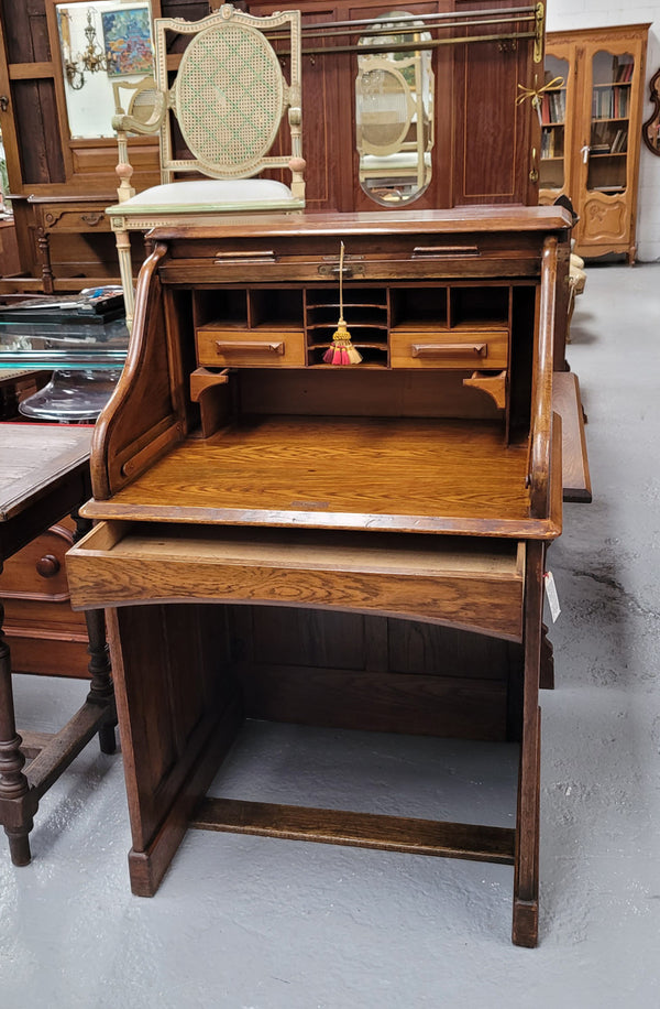 Charming petite English Oak fitted roll top desk. It has a very lovely fitted interior and a drawer at the front ideal for a unit or apartment. Sourced locally and in good original detailed condition.