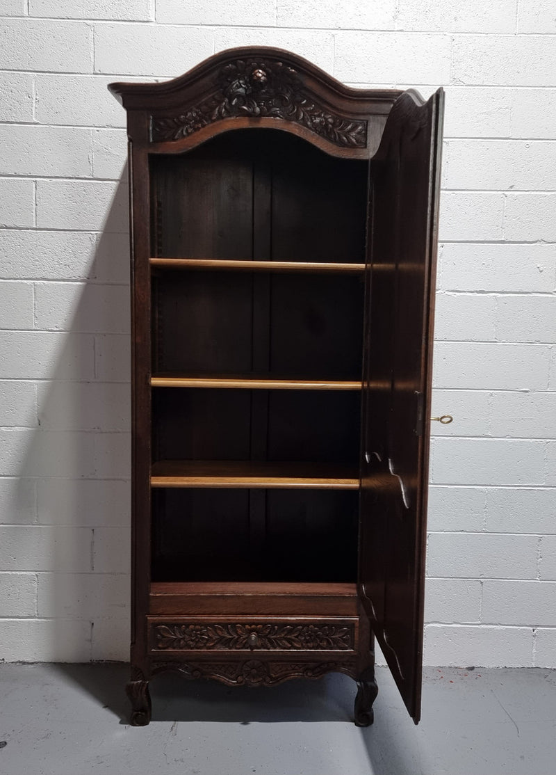 An Attractive French Louis XV style single-door ‘Marriage Armoire’. Beautifully arched crest with detailed carved flowers along with an arched single door which repeats the floral carvings. It is also has plenty of storage space with three adjustable shelves along with a drawer at the bottom. All in good original detailed condition.