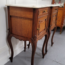 Pair of French Antique Louis XV style Oak marble top night stands. They have beautiful carved cabriole legs and beautiful white marble along with a drawer and cupboard for storage space. They have been sourced from France and are in good original detailed condition.