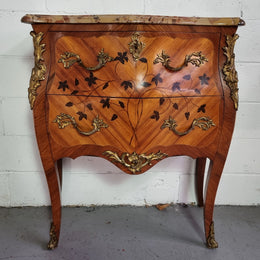 Charming petite French Louis XV style commode featuring two drawers, marquetry inlay, ormolu trim and marble Top. In good original detailed condition.  Circa: 1930’s.