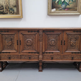 Large French Oak Renaissance style four door sideboard/buffet. Great decorative item with amazing carvings and stunning iron work on base. It is in good original detailed condition. Can pull apart completely making it easier to move.