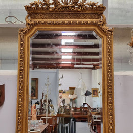 A stunning Napoleon III gilt mantle mirror with its original mirror. The top of the mirror is decorated with a beautiful laurel wreath and detailed decorative carving throughout. It is in good original condition with the bevelled mirror showing natural aging please view photo's.