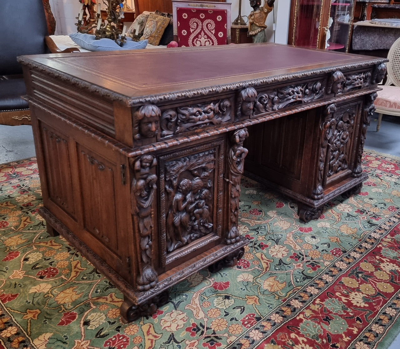 Beautifully carved French Oak early 19th century pedestal desk with 3 drawers, two cupboards and a secret cupboard on the side. There is also a lovely burgundy tooled leather top. In good original detailed condition.