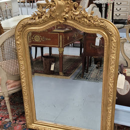 Beautiful French Napoleon III Louis XV style gilt framed bevelled mirror with an ornate crest on top. It has been sourced from France and is in good original detailed condition with the mirror showing signs of age.