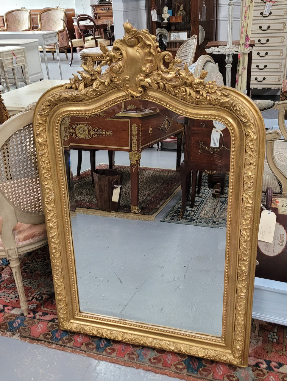 Beautiful French Napoleon III Louis XV style gilt framed bevelled mirror with an ornate crest on top. It has been sourced from France and is in good original detailed condition with the mirror showing signs of age.